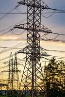 High voltage electric tower. Silhouette on sunset time. Power pylons on sunset time background. Selective focus photo