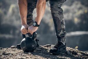 Athlete lifting weight. Nature landscape. Selective focus. Cropped photo. photo