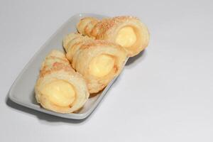 Cream puffs filled vanilla custard and dusted with icing on a rack photo