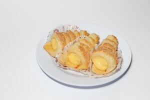 Cream puffs filled vanilla custard and dusted with icing on a rack photo