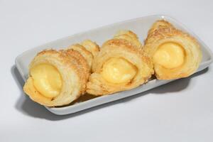 Cream puffs filled vanilla custard and dusted with icing on a rack photo