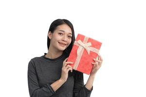 A woman is holding a red present with a bow on it. She is smiling and she is happy. Isolated on white background. photo