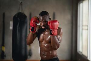 un hombre en un boxeo anillo con un rojo guante en su izquierda mano. él es transpiración y mirando determinado foto