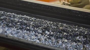 Pile of coal moves on belt conveyor at factory. Stock footage. Processing of raw materials or coal at plant. Conveyor for moving mass of raw materials during processing video
