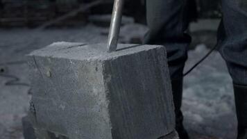 Man drills cement blocks. Clip. Worker splits cement blocks at construction site with hammer drill. Breaking apart cement blocks with drill video