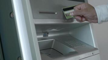 avvicinamento di uomo revoca i soldi a partire dal ATM. media. moderno bancomat con senza contatto i soldi ritiro. uomo mette carta per terminale e si ritira i soldi video