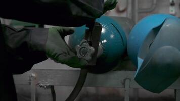 Close up of worker in gloves turning gas cylinder valve. Clip. Industrial background of the factory. video