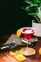 a red cocktail with orange slices on top photo