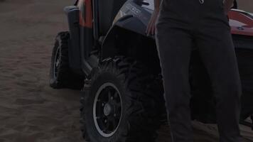 Dubai, Émirats arabes unis - 4 11 2018. Jeune femme dans tenue de sport permanent suivant à petit chariot sur désert le sable dunes contre le coucher du soleil Contexte video