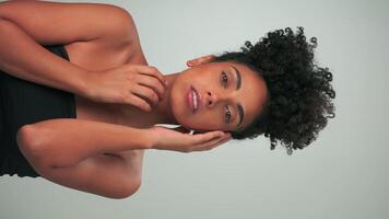 verticaal portret van jong glimlachen model- met gekruld haar- in afro stijl en helder bedenken video