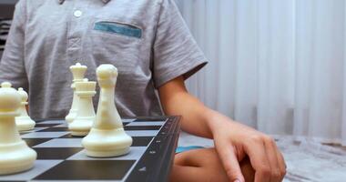 Boy wearing grey tee makes chess turn video