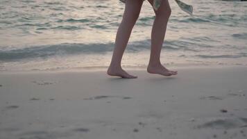 el pies de un joven mujer caminando el arenoso apuntalar video
