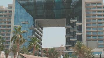 Young swarthy woman in a red bikini and a light dress walking barefoot in a private pool video