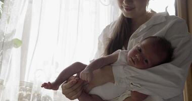 mãe vestindo branco camisa detém bebê em mãos video