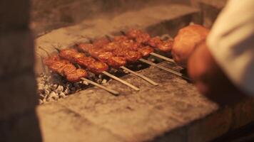 un del hombre mano voltea brochetas con parilla asado en el parrilla video