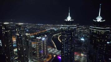Flying a drone over a night Dubai. Aerial view video