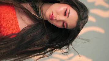 Vertical portrait of a young woman with long hair blowing in the wind and bright makeup video