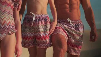 Young athletic man and son stand in shorts on the sand in the middle of the desert against the blue sky video