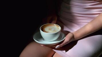 Close-up of cup of black coffee and saucer in female hands video