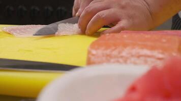 The chef cuts the red fish into slices on a board video