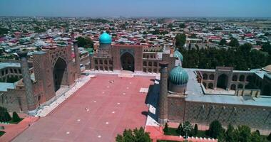 ein Drohne fliegt Über ein uralt Komplex bibi Khanym Moschee. sonnig Sommer- Tag. Samarkand, Usbekistan. video