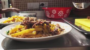 The chef puts the chopped meat in a plate with pilaf and carrots video