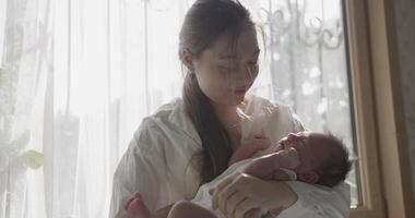 Mother wearing white shirt holds baby on hands video