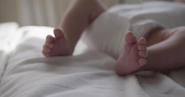 New born baby boy lies on the back on bedsheet video