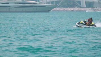 Dubái, uae - 5 5 22 2021. dos joven mujer en un scooter flotante en el mar bahía de dubai video