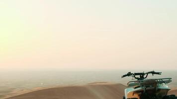 The quad bike stands on the sand dune of the desert of the United Arab Emirates against the sky video