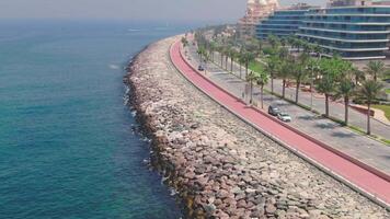 A drone flies over a road along the seashore near Dubai, United Arab Emirates video