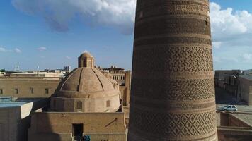 uma zangão moscas ao longo a minarete do a arquitetônico complexo poi-kalon dentro velho bucara, uzbequistão. nublado dia. video