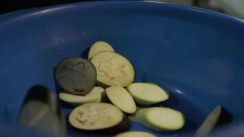 a chefe de cozinha lança fatiado legumes para dentro uma azul bacia video