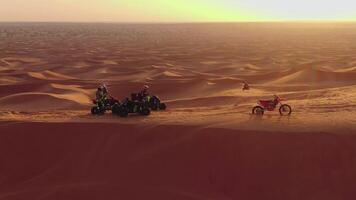 une drone mouches plus de quad vélos conduite par le le sable dunes de le désert dans le uni arabe émirats video