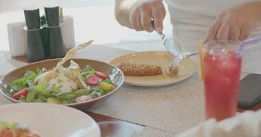 ein Familie beim ein Tabelle im ein Restaurant von ein teuer Luxus Hotel. Salate, Pasta, Wein Brille mit Saft und Cocktails sind auf das Tabelle video