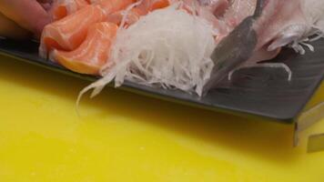 fabbricazione Sushi con daikon, le foglie e tagliare pesce video