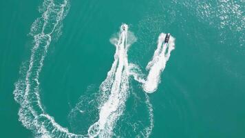 Dubai, UAE - 3 20 2023. A drone flies over people riding jet skis on the sea next to a yacht with Dubai in the background. video