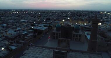 een dar vliegt over- de oud stad en de beroemd gedenkteken complex ikalyan poi kalon complex en poi kalon minaret n bukhara Bij dageraad video