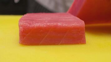 The chef cuts the red fish into slices on a board video