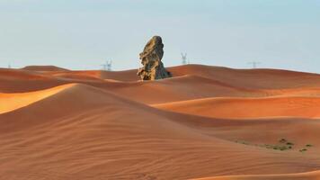 A drone over a rock standing among a sandy desert video