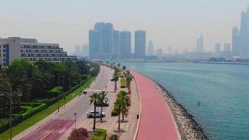 uma zangão moscas sobre uma estrada ao longo a Beira Mar perto dubai, Unidos árabe Emirados video