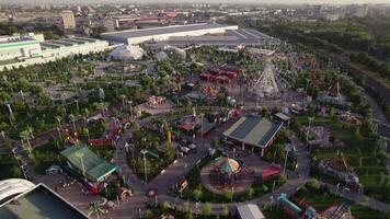 A drone flies over an amusement park with carousels and a Ferris wheel video