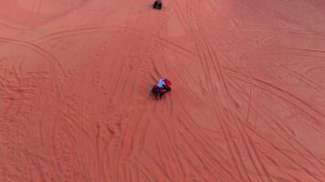 A drone flies over quad bikes driving through the sand dunes of the desert in the United Arab Emirates video