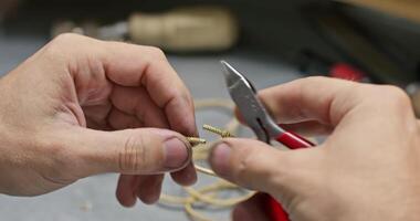 Jeweler collects jewelry with tweezers on the table video