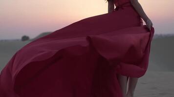jung Frau mit schwarz Haar Stehen barfuß im ein lange rot Abend Kleid auf das Sand Dünen von das Wüste video