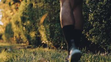 atlético corredor haciendo extensión ejercicio, preparando para corriendo en el naturaleza con el ciudad en antecedentes. sano estilo de vida video