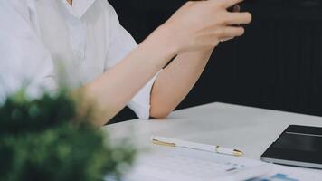 Silhouette eines beschnittenen Schusses eines jungen Mannes, der von zu Hause aus mit Smartphone und Notebook arbeitet, die Hände des Mannes mit Smartphone im Innenraum, Mann an seinem Arbeitsplatz mit Technologie, Fackellicht video