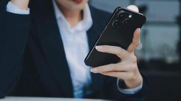 silueta de una foto recortada de un joven que trabaja desde casa usando un teléfono inteligente y una computadora portátil, las manos del hombre usando un teléfono inteligente en el interior, un hombre en su lugar de trabajo usando tecnología, luz de bengala video