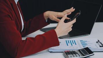 Silhouette of cropped shot of a young man working from home using smart phone and notebook computer, man's hands using smart phone in interior, man at his workplace using technology, flare light video