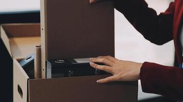 Upset female employee packing belongings in box, frustrated stressed girl getting fired from job ready to leave on last day at work. sad office worker desperate from work video